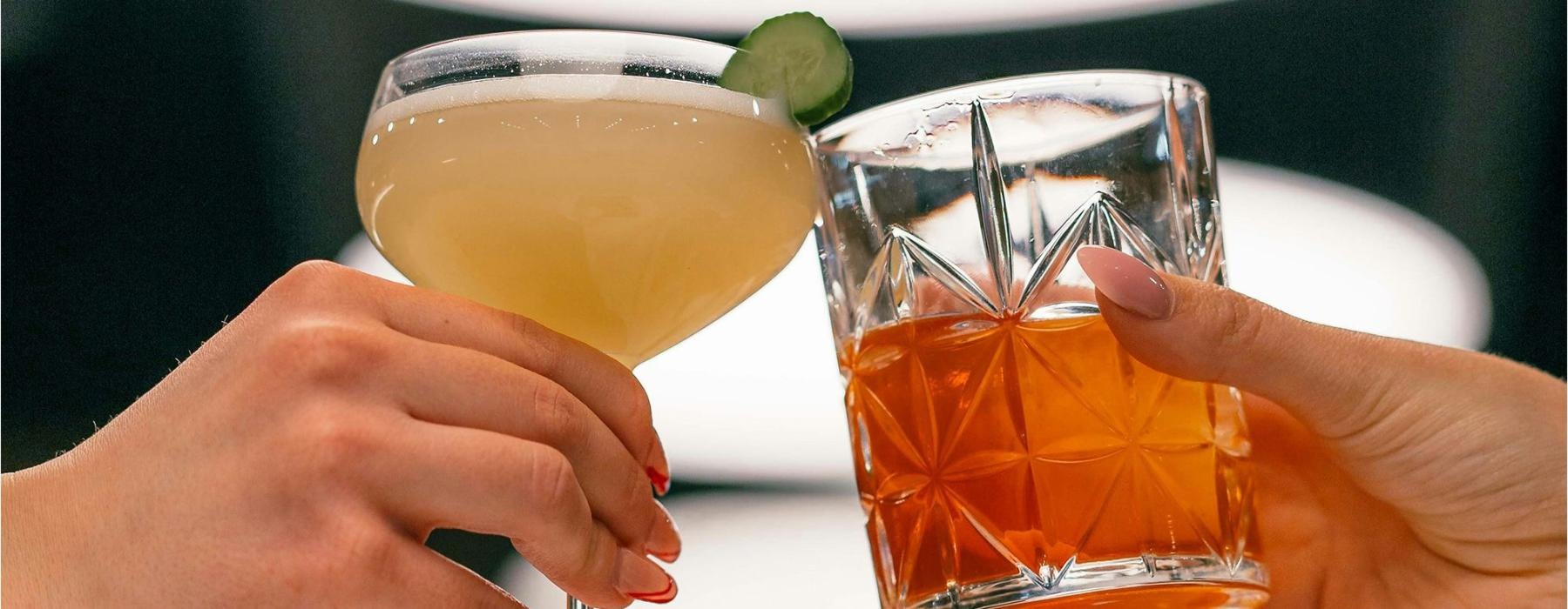 hands holding glasses with cocktails