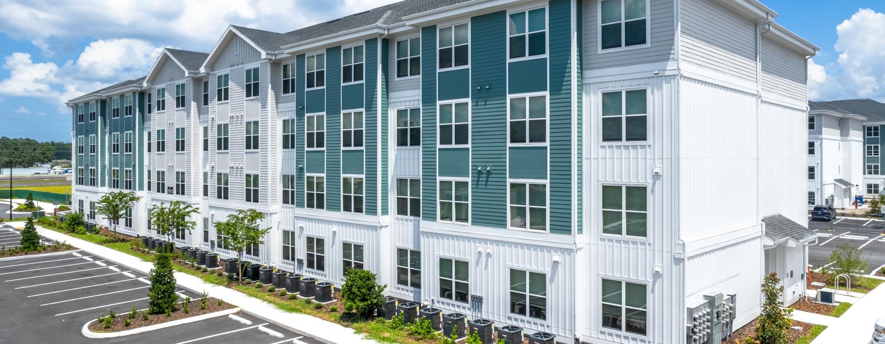 a large white building with a parking lot
